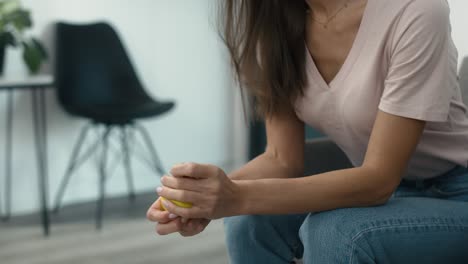 unrecognizable caucasian woman sitting in clinic waiting room and squeezing a stress ball