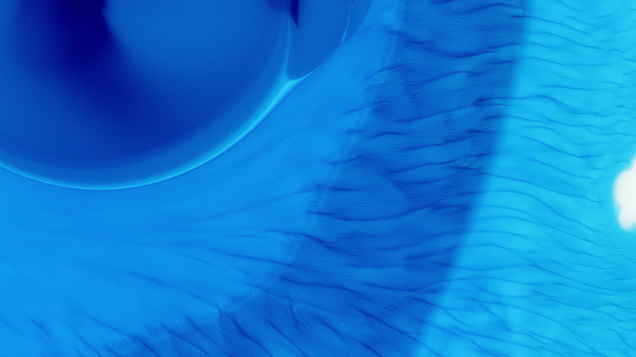 파란색 잉크 니가 물 속에 천천히 퍼져 나가고, 계층화된 그라디언트 색조로 소용돌이 치고 있습니다.