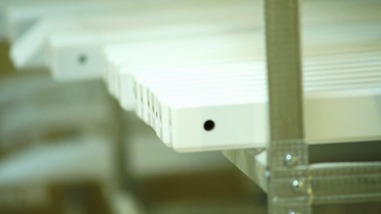 색으로 칠한 목조 부품이 건조 라크에 있습니다.