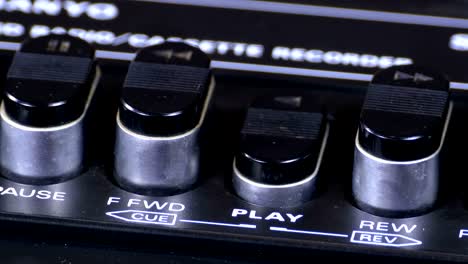 pushing play button on a vintage tape recorder