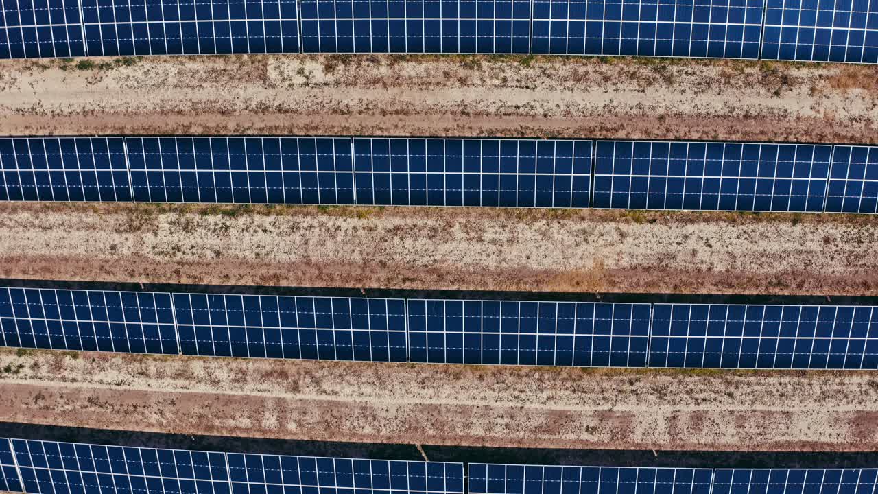 Veduta aerea dall'alto di file di pannelli solari in un grande impianto solare.