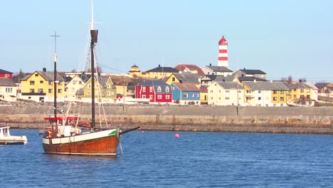 establishing shot of small picturesque fishing village with lighthouse along the coast of norway 1