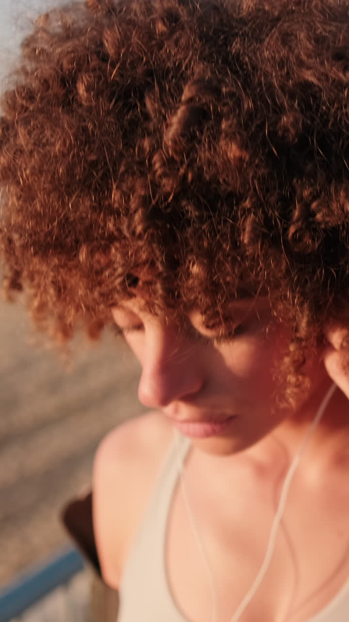 mujer escuchando música en la playa