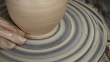 the potter makes a jug of clay. ceramist. a man makes a vase on a potter's wheel