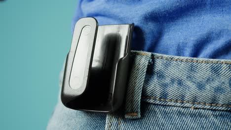 person holding and wearing a medical alert device