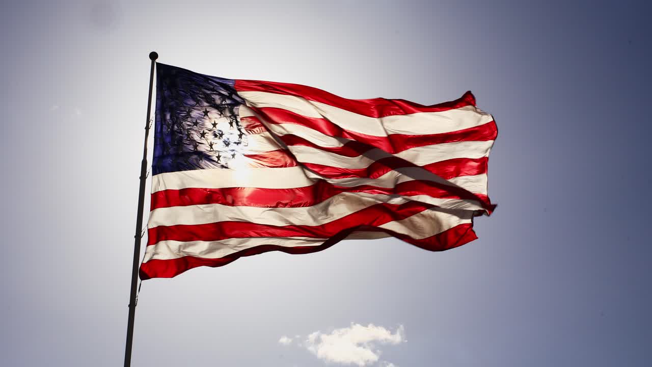 Bandiera degli Stati Uniti d'America che sventola in alto al vento con sfondo di cielo blu