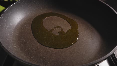 olive oil dripping onto heated pan on the stove