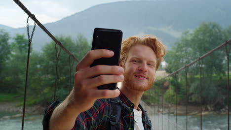 talking tourist using smartphone make video call on summer mountains closeup.