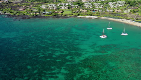 drone footage of 3 sailboats, in a bay, off the big island of hawaii