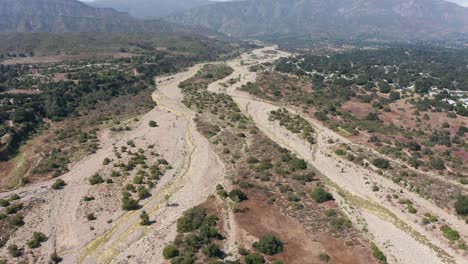 Rising-aerial-shot-flying-over-the-dried-Ventura-River-riverbed-in-Ojai-Valley,-California