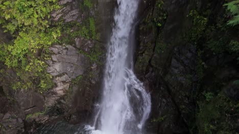 Drone-Flying-Up-Revealing-Epic-Waterfall-in-Tropical-Jungle-in-Alegria,-Philippines