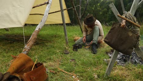 Australian bushman eats his meal by his historical hut in the bush
