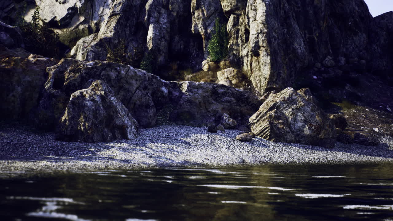 Rocky shoreline by calm water with lush greenery under bright sky
