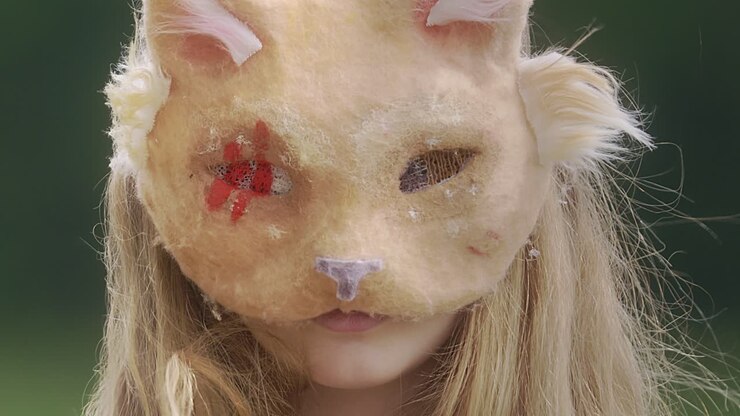 Ragazza con maschera da gatto al rallentatore in primo piano
