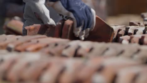 unrecognizable workers lay down ceramic tiles in row on deconstruction site, close up