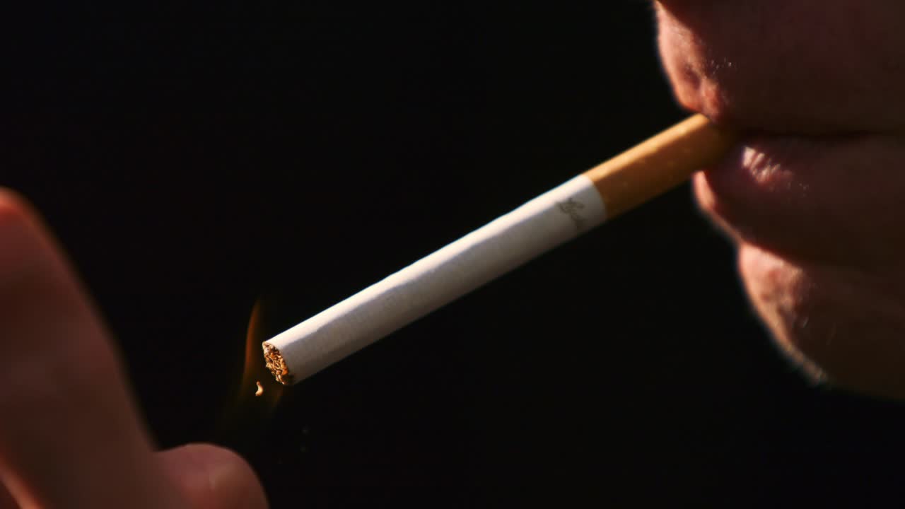 hombre encendiendo y fumando un cigarrillo en súper cámara lenta
