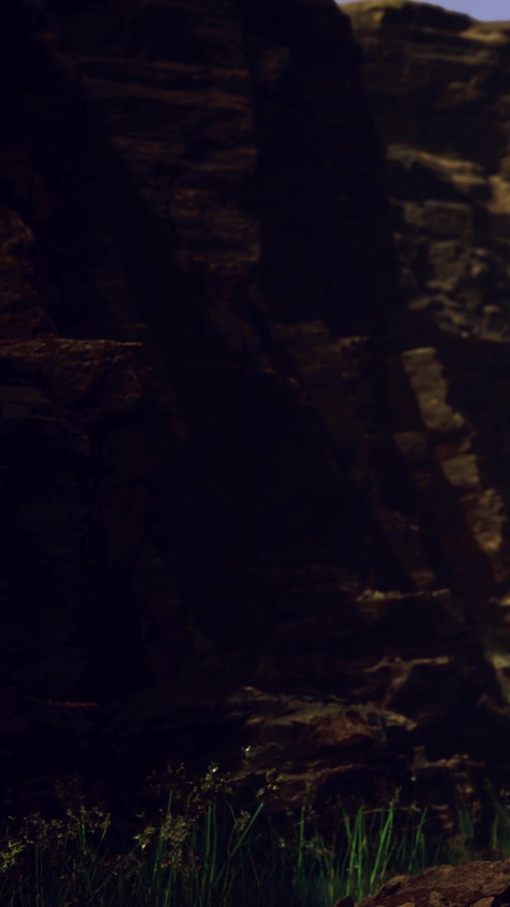 Light shines on rocks in dark cave near water at dusk