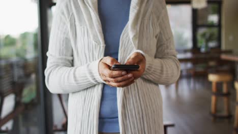 Mid-section-of-senior-mixed-race-woman-using-smartphone