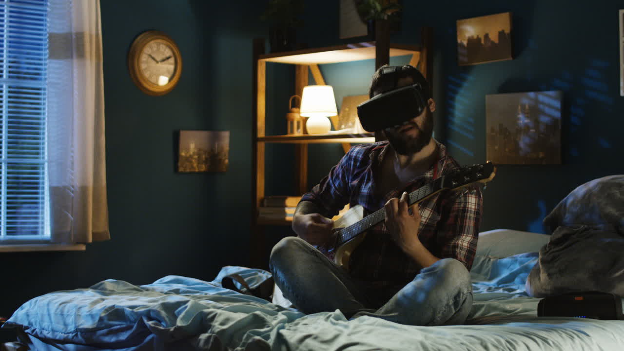 Man Playing Guitar with VR Headset in Bedroom