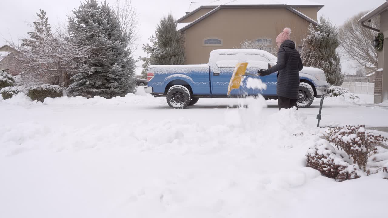 señor mujer paleando nieve después de una tormenta