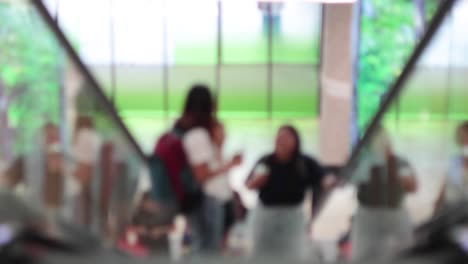 group ascending on an indoor escalator, interacting casually.