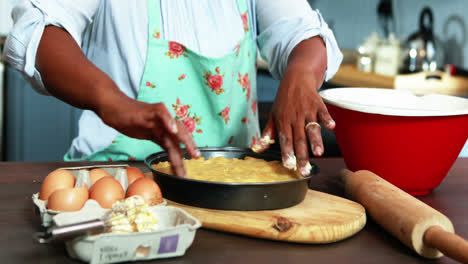 mujer mayor preparando comida dulce en la cocina