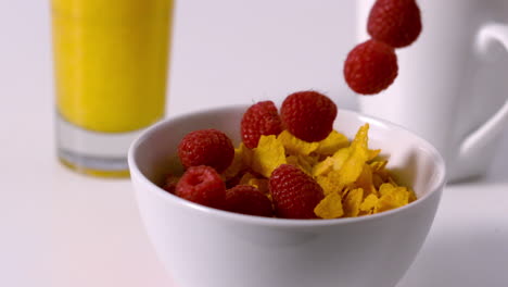 Frambuesas-Vertiendo-En-Un-Tazón-De-Cereal-En-La-Mesa-Del-Desayuno