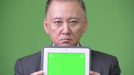 mature japanese businessman showing digital tablet