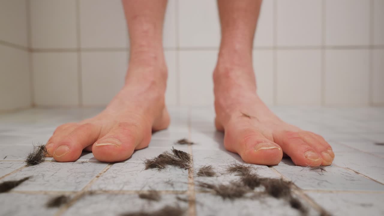 Dark hair falling in front of a man's feet