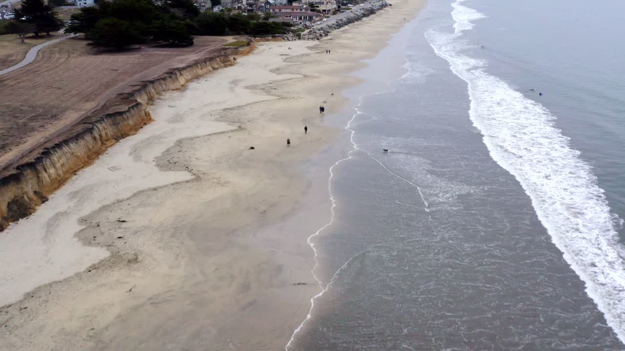 aéreo: drone, acantilados de la playa de half moon bay, gente y costa, vista hacia adelante volando
