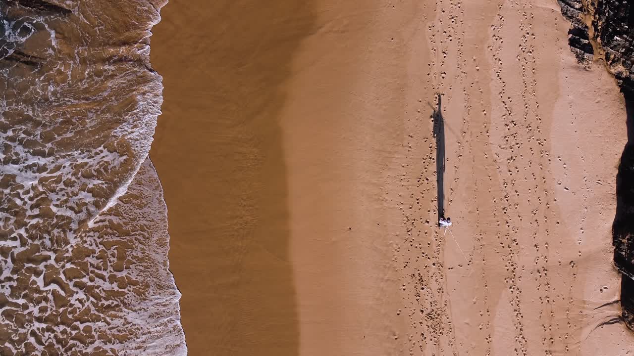 A fisherman walking along the shore in the Algarve, Portugal