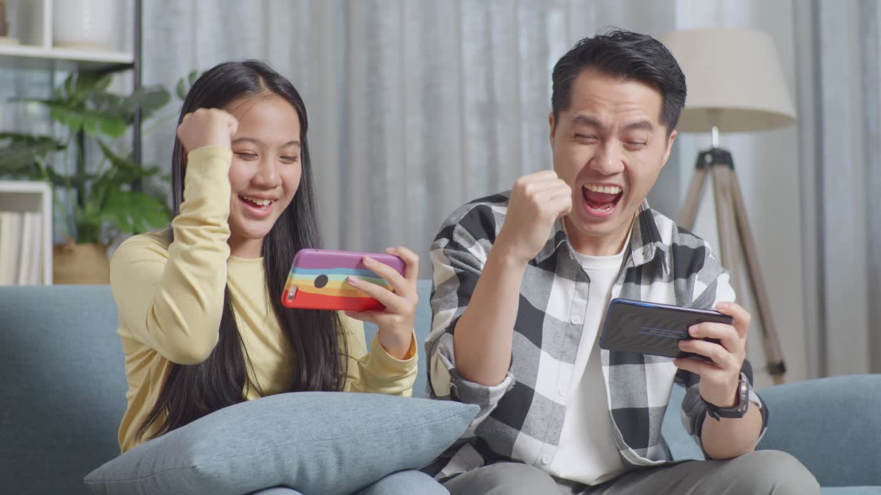 幸せな家族がモバイルゲームをしている