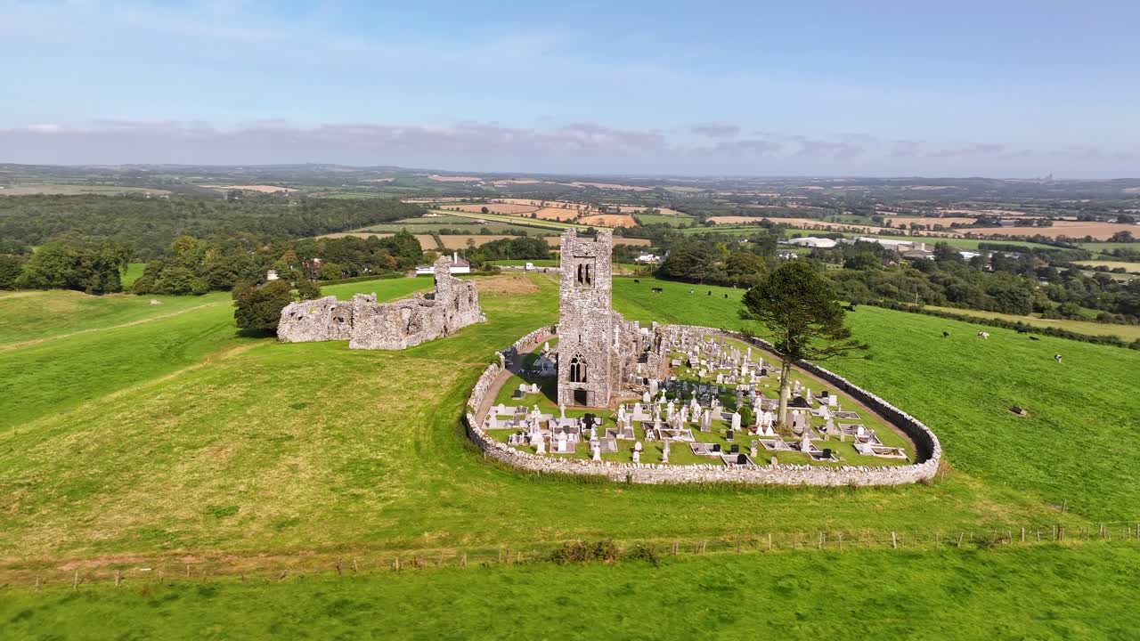 Aerial close up of Slane Abbey historical landmark on hill, views of green Irish landscape