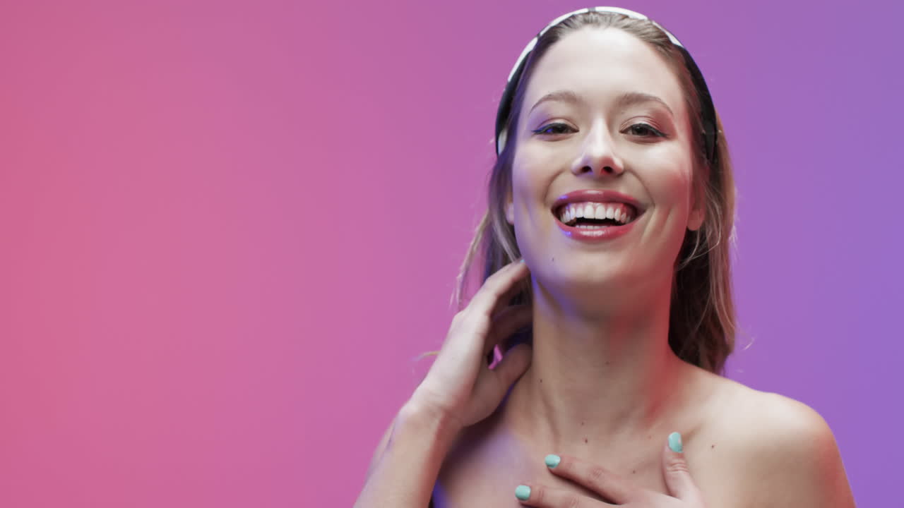 Donna caucasica sorridente con capelli biondi e trucco che si tocca il collo, spazio per il testo, rallentatore