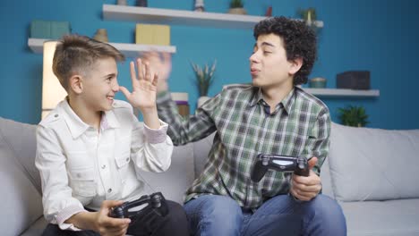 brothers play video game with game consoles at home.