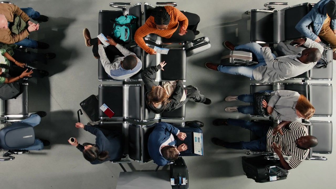 Businessman working on laptop while waiting in crowded airport