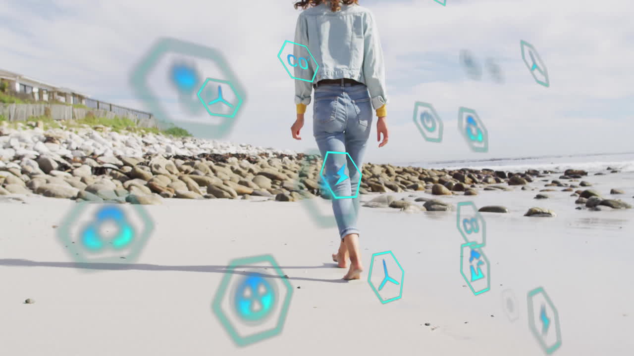 Woman walking barefoot on sandy beach, surrounded by floating hex icons showing clean energy tech