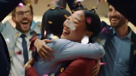 celebration of friendship: two women embrace joyfully amidst confetti and laughter in a warmly lit gathering
