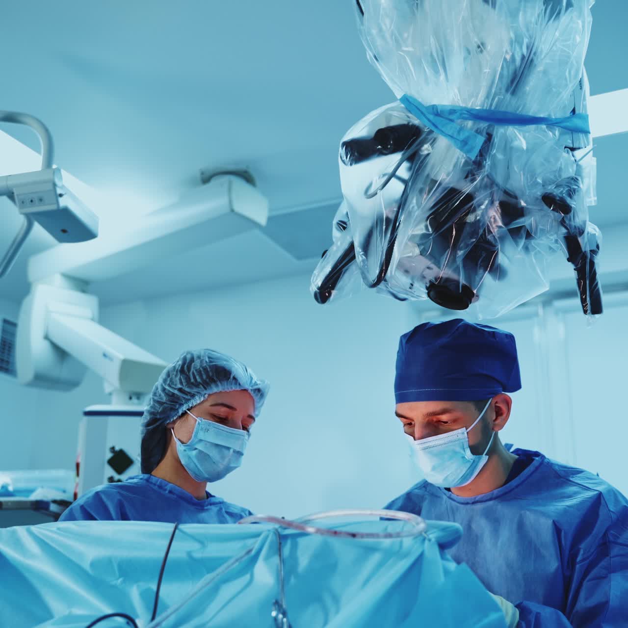 Surgeons working in the operational room with advanced equipment. Doctor operating the patient assisted by female nurse
