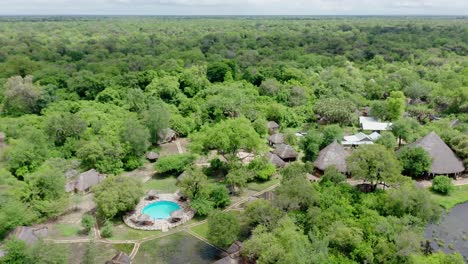 aerial drone shot flying sideways over a luxury lodge in selous jungle, tanzania.