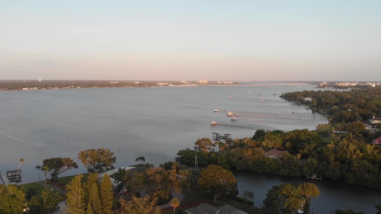 Veduta aerea di un bayou della Florida meridionale che sfocia in un fiume con moli lungo la riva al tramonto