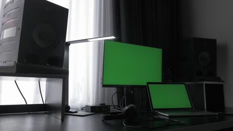 modern workplace with laptop computers, green screens and studio monitors in office. chroma key green screen. green screen laptop computer at home work desk