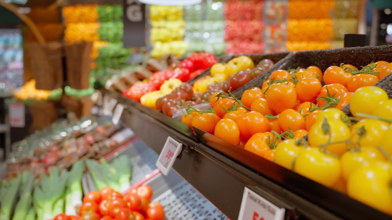 Grande variedade de tomates e vegetais coloridos expostos em prateleiras em um supermercado