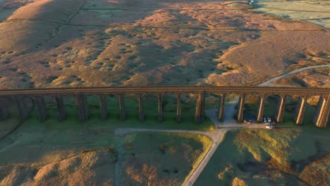 railway bridge with arches spanning barren english moorland at sunrise in winter