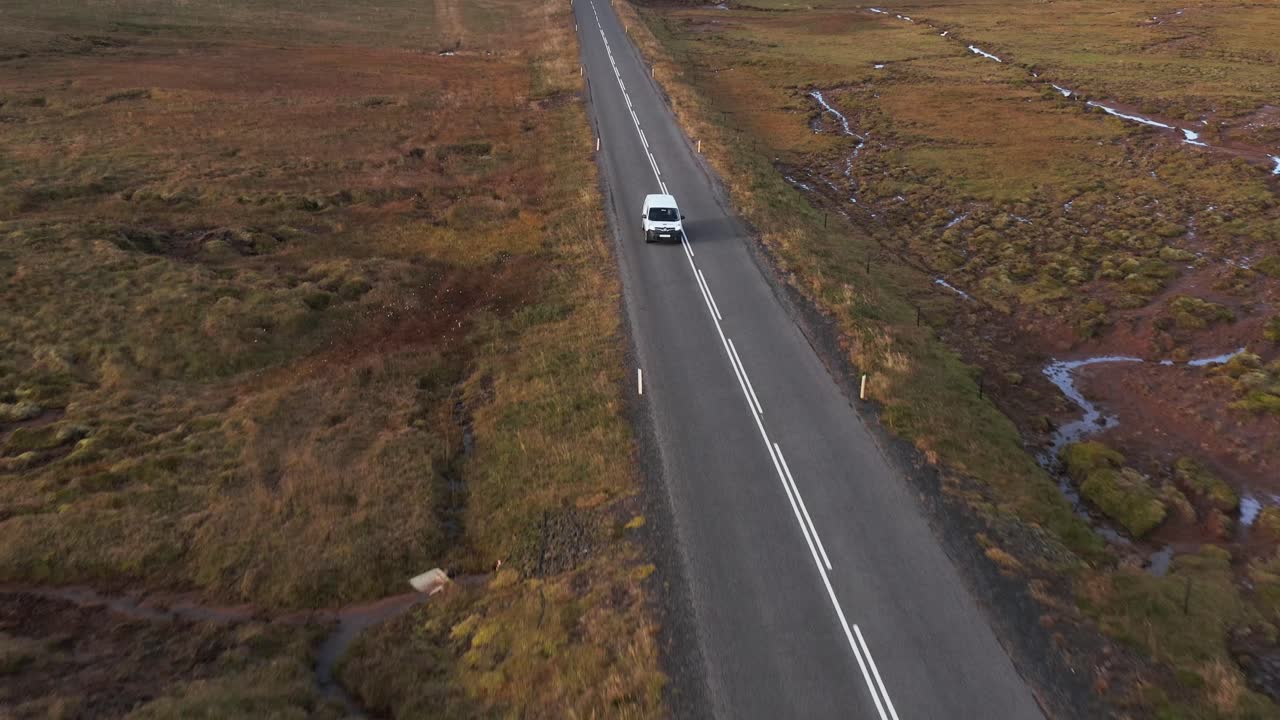 Auto che viaggia attraverso un paesaggio della tundra al crepuscolo, ripresa aerea.