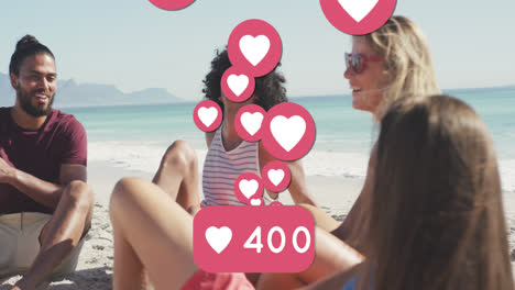 animation of love heart digital icons and numbers over group of friends on beach