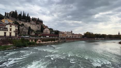 Amplia-Vista-Panorámica-Del-Paisaje-Urbano-Del-Casco-Antiguo-De-Verona-Desde-El-Río-Adige-En-Un-Día-Nublado