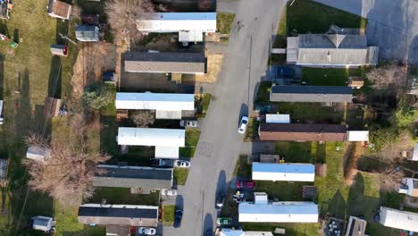 Top-down-aerial-of-mobile-home-trailer-park-in-winter-golden-hour-light