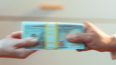 a tug of war over a stack of cash between a caucasian woman and latino male