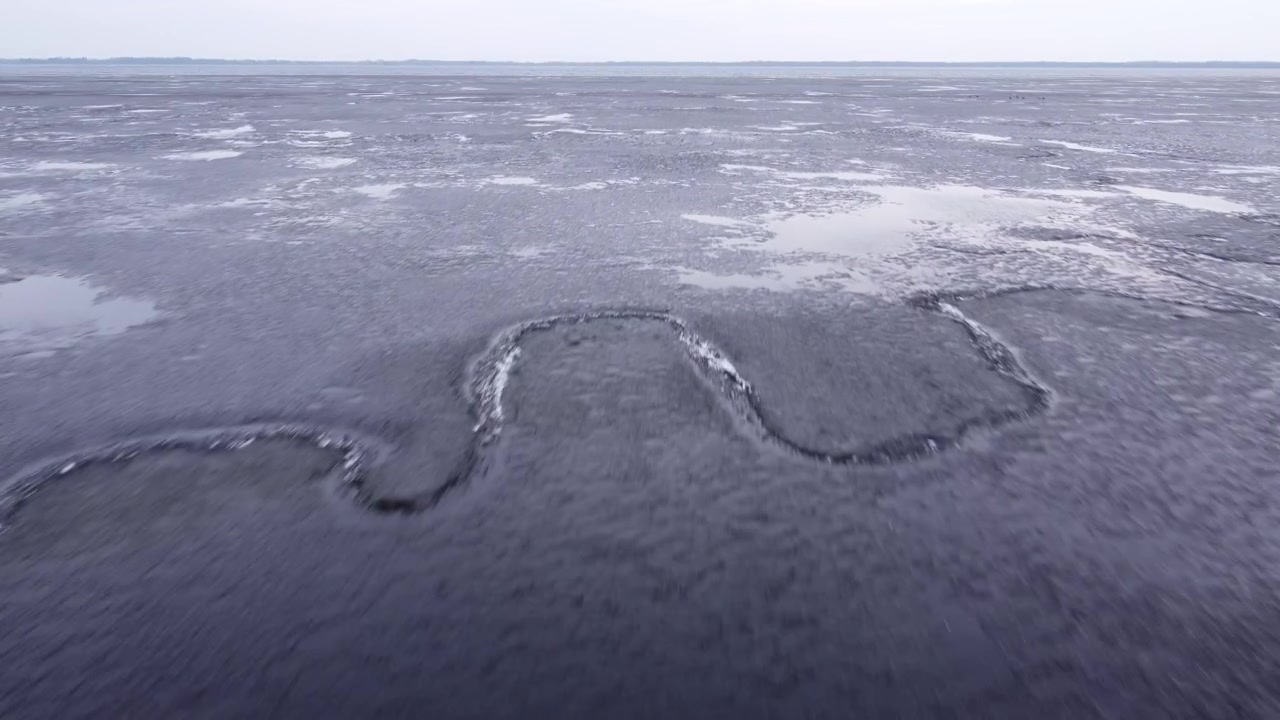 Last brittle and dangerous ice with crack on the lake in the spring.